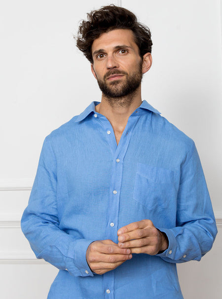 Man wearing a sky blue long sleeved shirt with pocket detail made with 100% linen in a Thomas Mason fabric.